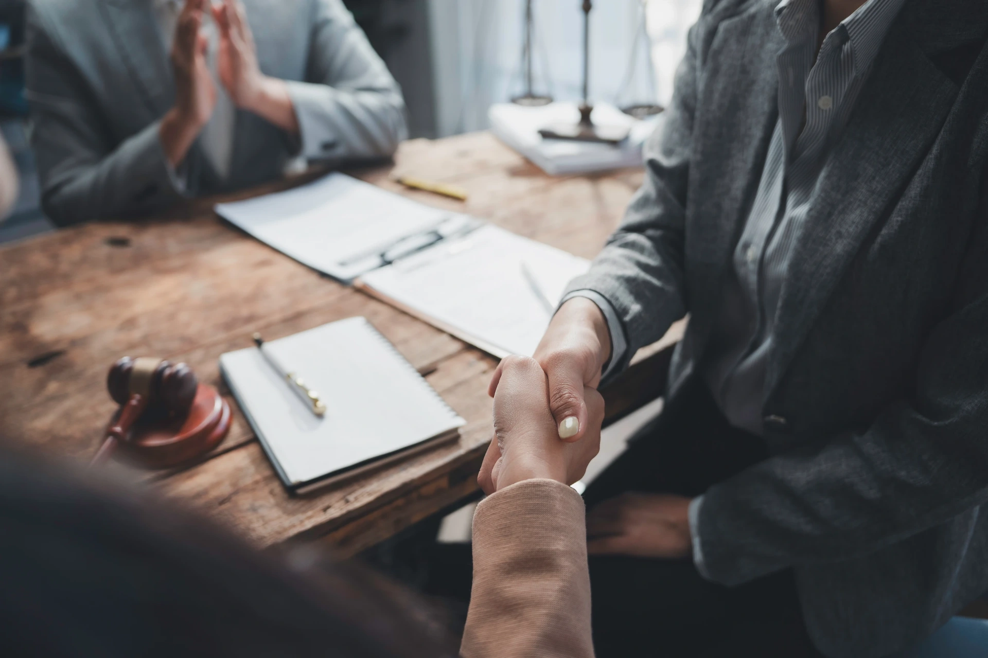 Attorney shaking hands with a client after a successful case settlement